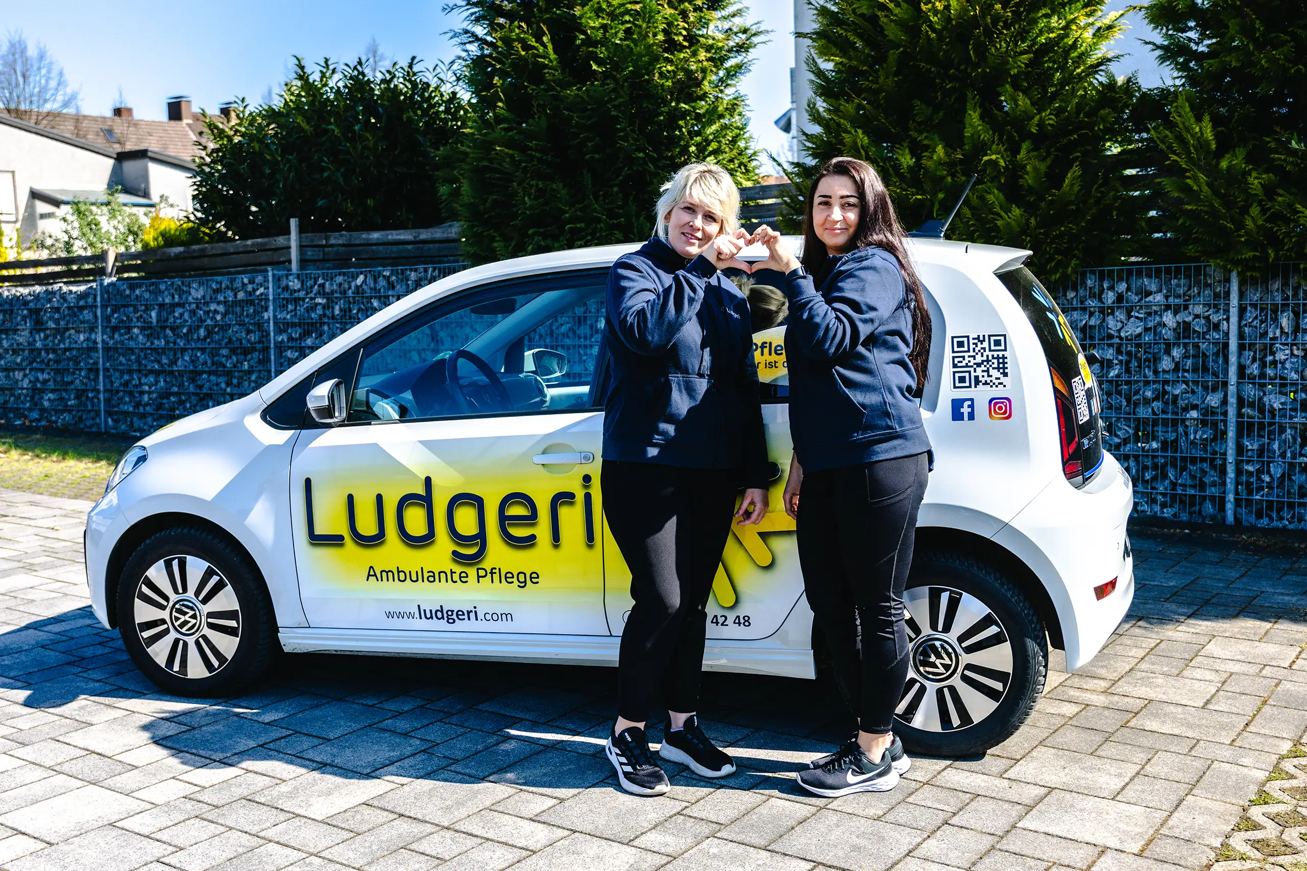 Ludgeri Mitarbeiter machen ein Herz Auto im Hintergrund